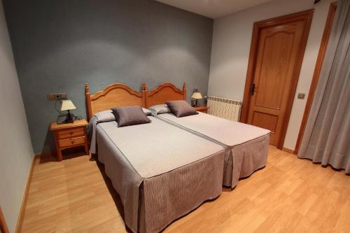a bedroom with a large bed with a wooden headboard at El Pedrís in El Pont de Suert