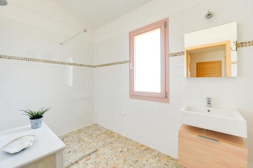 un bagno bianco con lavandino e specchio di Les Hameaux De Buttaciolo a Cuo