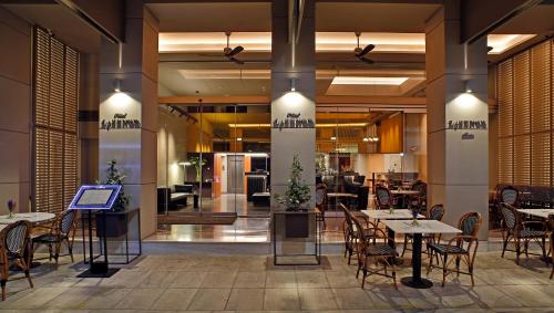 a restaurant with tables and chairs in a lobby at Hotel Lozenge in Athens