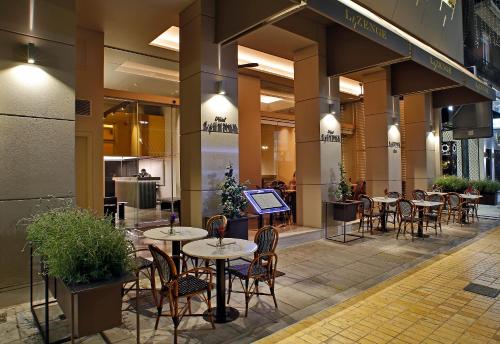 a restaurant with tables and chairs in a building at Hotel Lozenge in Athens