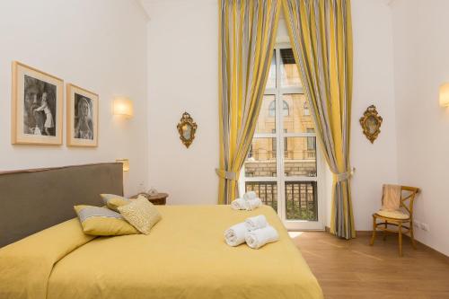 ein Schlafzimmer mit einem gelben Bett mit Handtüchern darauf in der Unterkunft Prestigious Apartment via Barberini in Rom