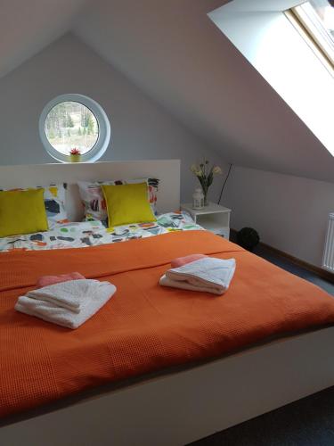 カルパチにあるApartment Karpaczのベッドルーム1室(窓、オレンジ色のベッド1台付)