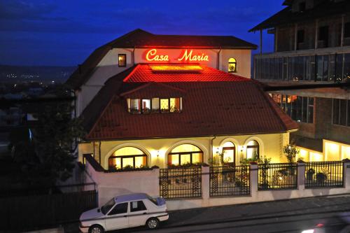 a car parked in front of a building with a sign on it at Casa Maria Arges in Piteşti