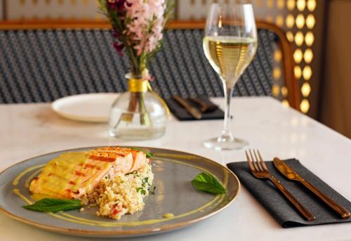 a plate of food on a table with a glass of wine at Hotel Lozenge in Athens