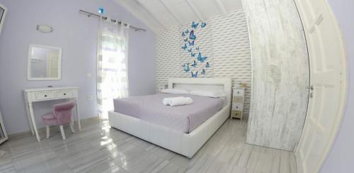 a white bedroom with a bed and a pink chair at LUXURY JUST FOR 2 in Halikounas