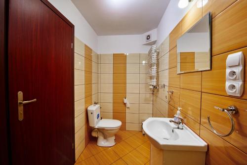 a bathroom with a white toilet and a sink at Pensjonat pod Kasztanem in Ełk