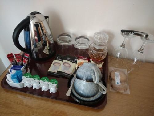 a tray with a tea kettle and other items on a table at Ardlair Guest House in Ullapool