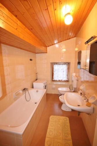 a bathroom with two toilets and a tub and a sink at Casa Katia in Canale dʼAgordo