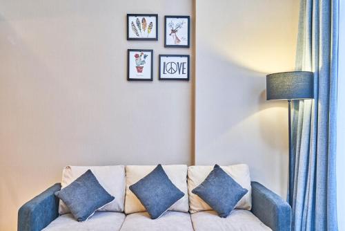 a living room with a couch and framed pictures on the wall at Plesant Daily Rental Apartment in Hangzhou
