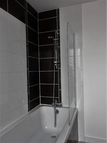 une salle de bain avec baignoire et douche dans l'établissement Maison Rouge, au Guilvinec