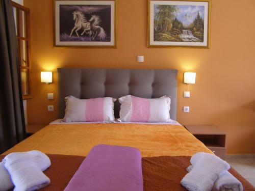 a bedroom with a large bed with two towels on it at Milos Studios in Parga