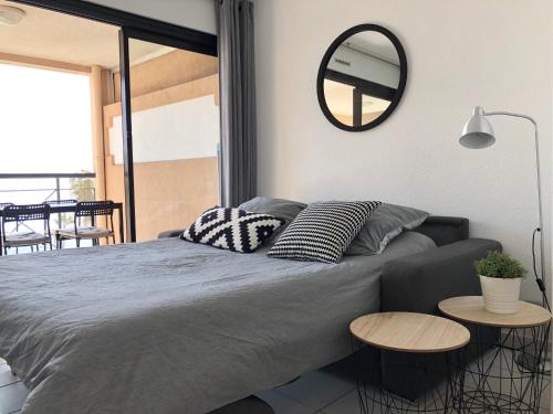 une chambre avec un grand lit avec un miroir au mur dans l'établissement Appartement Vue Mer Cannes Azur, à Cannes