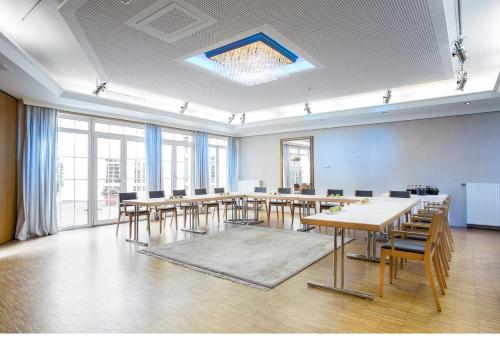 ein großer Raum mit Tischen und Stühlen und Fenstern in der Unterkunft Das Goldene Lamm Aalen in Aalen