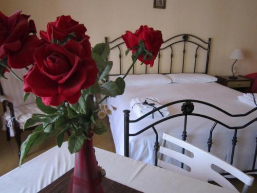a bed with flowers and a vase of roses on top of it at Da Mary Guest House in Palermo