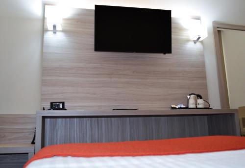a bedroom with a flat screen tv on a wall at Best Western Park Hotel in Piacenza