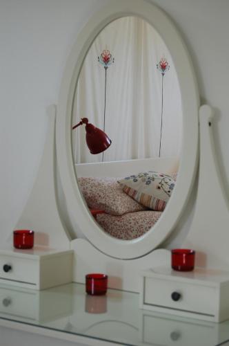 a bedroom with a mirror on a bed with red candles at Bed & Breakfast La Volpe e L'Uva in Santa Marinella