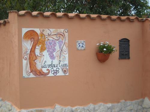 a sign on the side of a building with a flower pot at Bed & Breakfast La Volpe e L'Uva in Santa Marinella
