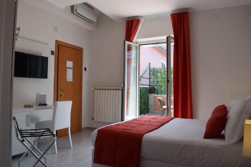 a bedroom with a bed and a desk and a window at Hotel Lido in Varazze