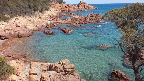 a body of water with rocks and the ocean at Sa Perda Arrubia in Cardedu