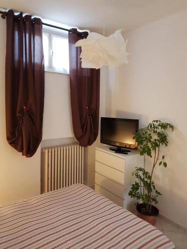 um quarto com uma cama, uma televisão e uma janela em Come a casa em Villastellone