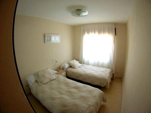 Habitación de hotel con 2 camas y espejo en Villa Buenavista, en Málaga