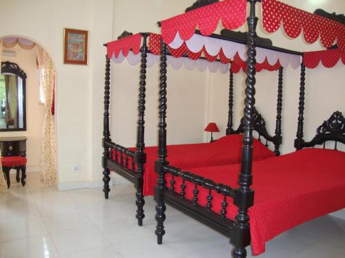 a bedroom with a red bed with a red canopy at Baruah Bhavan Homestay in Guwahati