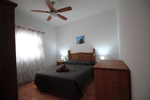 - une chambre avec un lit et un ventilateur de plafond dans l'établissement MONTAÑA VALLES DE ORTEGA -C, à Valles de Ortega