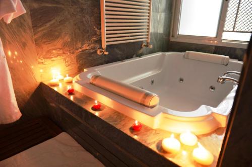 a bathroom with a tub with candles on a counter at Massabki Hotel in Chtaura