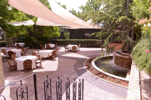 patio ze stołami, krzesłami i fontanną w obiekcie Massabki Hotel w mieście Chtaura