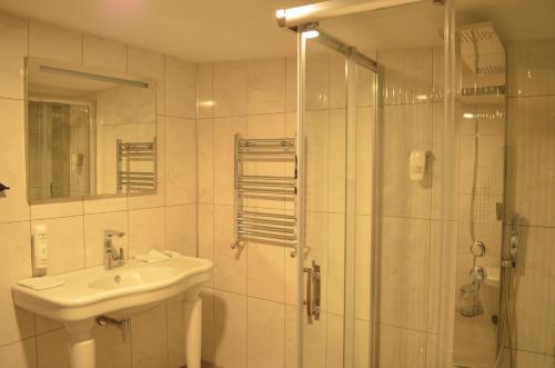 uma casa de banho branca com um lavatório e um chuveiro em Senler Boutique Hotel em Sapanca