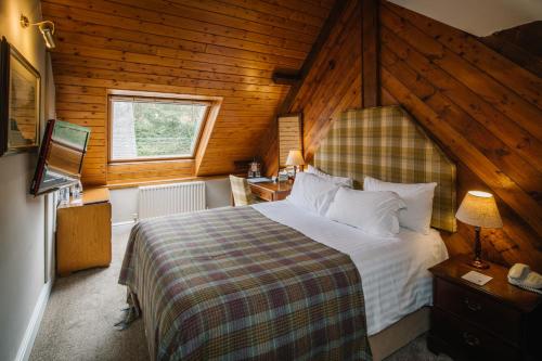 een slaapkamer met een groot bed in een houten kamer bij Lindeth Howe in Bowness-on-Windermere