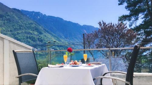 a table with a plate of food and a flower on it at Montreux Lake View Apartments and Spa - Swiss Hotel Apartments in Montreux