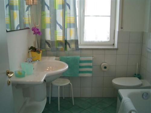 a bathroom with a sink and a toilet and a window at Villa Linke am Bodensee in Nonnenhorn