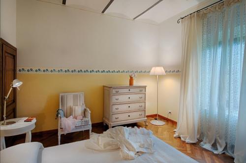 een slaapkamer met een bed, een dressoir en een wieg bij Tenuta Cambiano by PosarelliVillas in Castelfiorentino