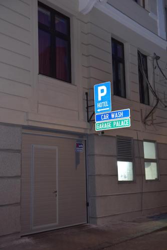 a car wash garage with a parking sign in front of a building at Palace Hotel in Belgrade