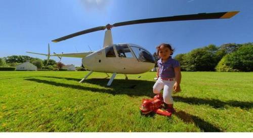 a young child standing in front of a helicopter at Gîtes de La Ferme De Kereven in Bénodet