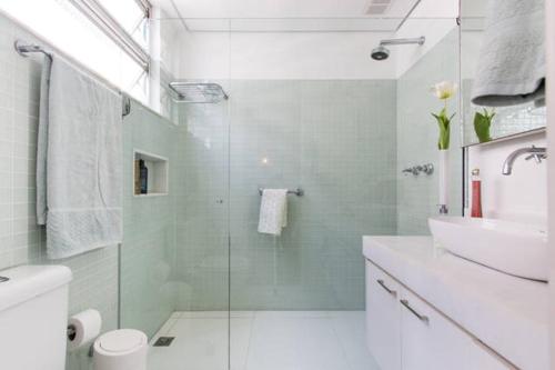 La salle de bains est pourvue d'une douche en verre et d'un lavabo. dans l'établissement Posto 4- Copacabana vista total mar 1003, à Rio de Janeiro