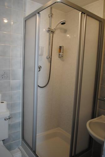 a shower with a glass door in a bathroom at Craig-Ard Hotel in Llandudno