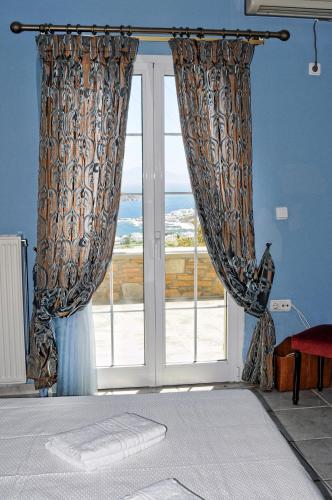 a bedroom with a window with a view of the ocean at The Blue Horizon Villa in Livadi