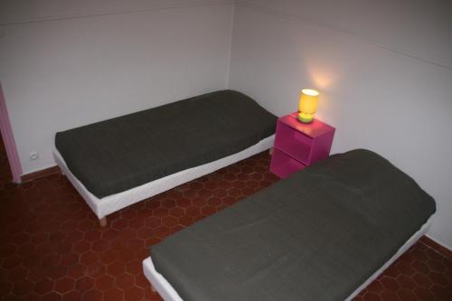 a room with two beds and a candle on a table at Village Camping Les Vignes in Puy-lʼÉvêque
