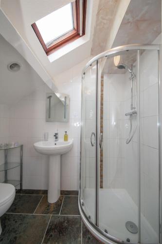 a bathroom with a glass shower and a sink at The Coppice - including off-site health club in Windermere