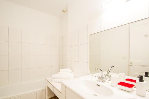 a white bathroom with a sink and a mirror at Le Poete by Cocoonr in Toulouse