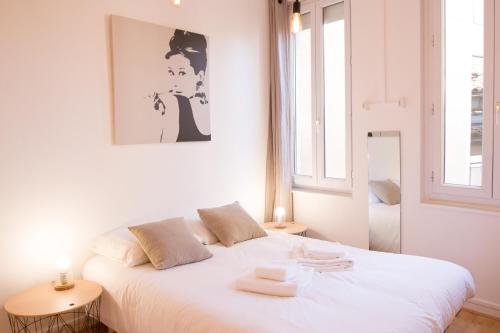 a bedroom with a white bed with two tables at Le Poete by Cocoonr in Toulouse