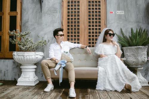 a bride and groom sitting on a couch at House Of Passion Amphawa in Amphawa