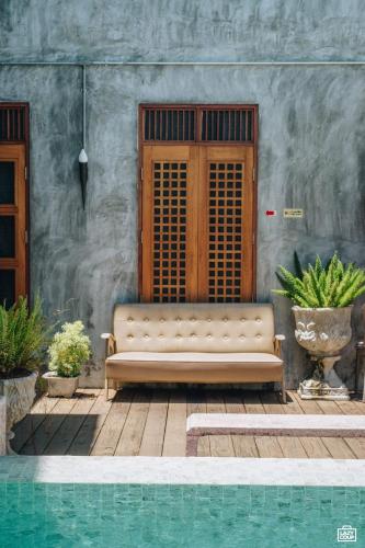 a couch sitting in front of a building next to a pool at House Of Passion Amphawa in Amphawa