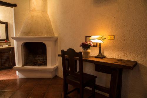 a room with a fireplace and a table with a lamp at Posada El Antaño in Antigua Guatemala