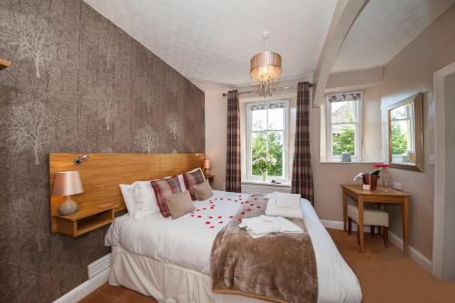 a bedroom with a large bed and two windows at The Coppice - including off-site health club in Windermere