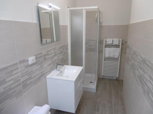 a white bathroom with a sink and a shower at Hotel Villa Maria in Sanremo