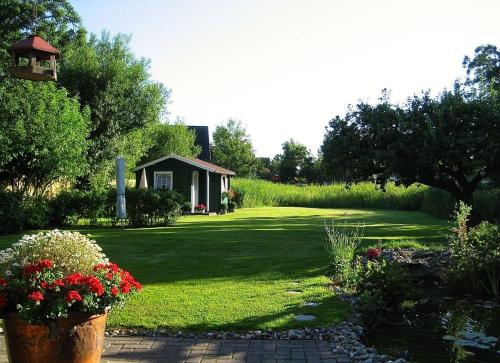 a garden with a house and a yard with flowers at Nordsee Haus An't Oll Deep in Dornumersiel