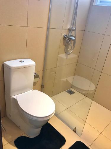 a bathroom with a toilet and a shower at Araliya OceanFront Condos Nilaveli, Trincomalee in Nilaveli